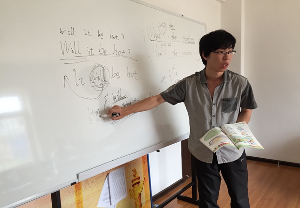 志愿者李浩杰为小学生讲解英语